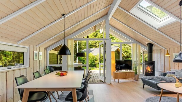 A spacious interior with a high ceiling, a dining area, a living room with a fireplace, and large windows offering views of the outdoors. - "Anastaja" - 12km from the sea by Interhome (Oksbøl)
