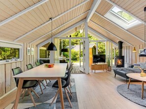 A spacious interior with a high ceiling, a dining area, a living room with a fireplace, and large windows offering views of the outdoors. - "Anastaja" - 12km from the sea by Interhome (Oksbøl)