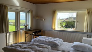 Un dormitorio con dos camas, un escritorio y vistas al exterior.