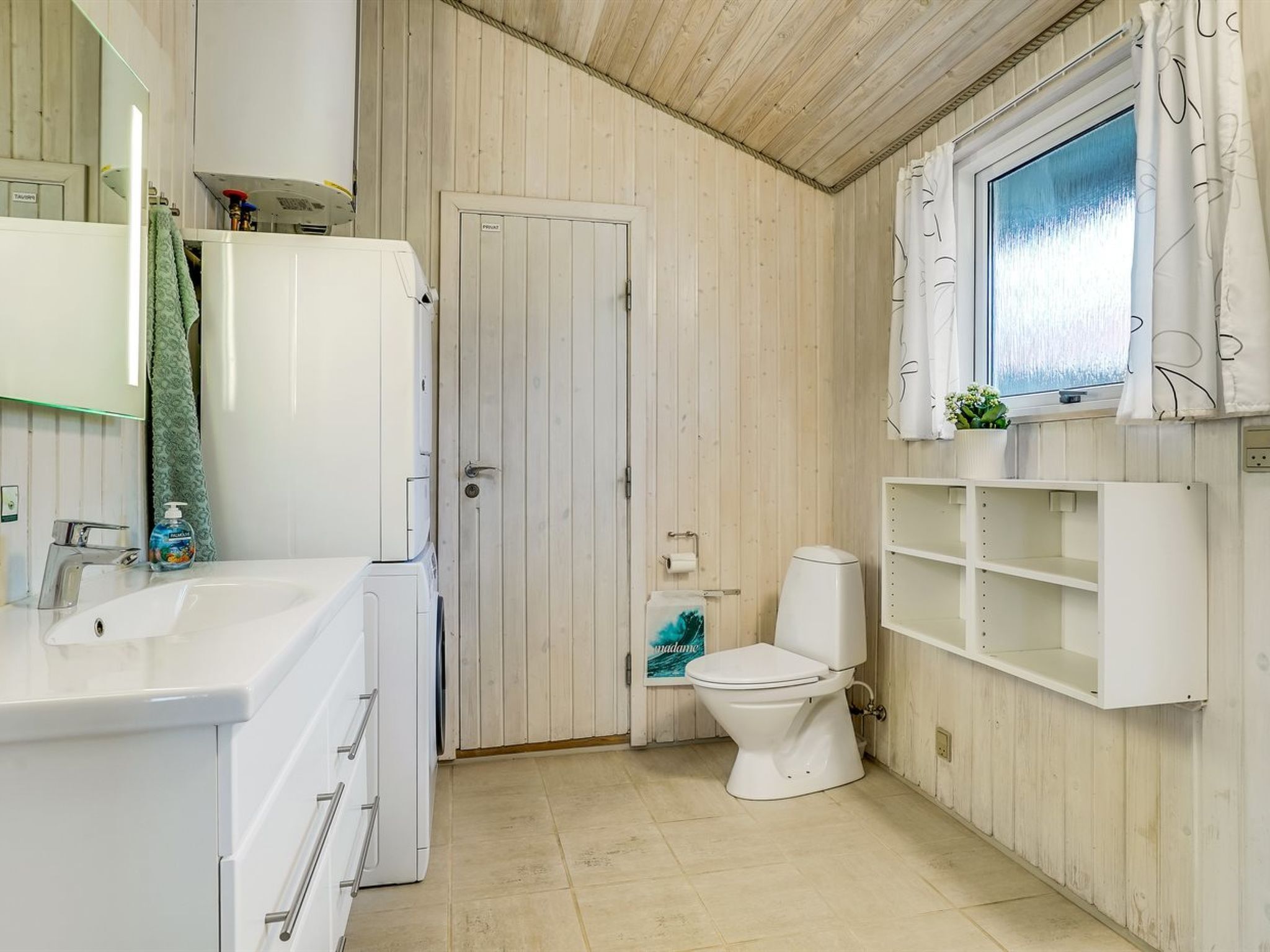 A bathroom with a white sink, a toilet, and a shower area.