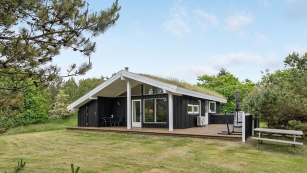 A modern cabin with a large deck, a covered outdoor seating area, and a picnic table. - "Evan" - 1.3km from the sea by Interhome (Pandrup)
