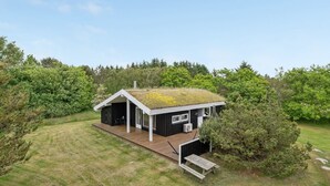 A modern house with a sloped roof, a deck, and a small outdoor seating area. - "Evan" - 1.3km from the sea by Interhome (Pandrup)