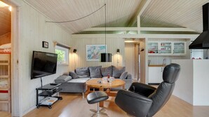 A modern living room with a sofa, a black leather chair, a TV, and a dining table. - "Evan" - 1.3km from the sea by Interhome (Pandrup)