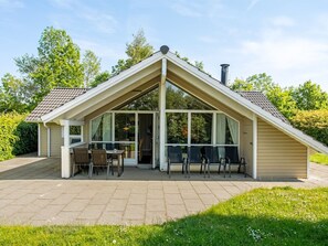 Einbungalow mit Satteldach und überdachter Terrasse.