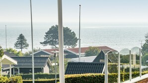 Un quartier résidentiel situé sur la côte, où les maisons se caractérisent par leurs toits inclinés et offrent une vue sur la mer.