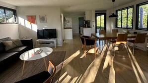 Ett modernt vardagsrum med en soffa, en tv och en matplats.