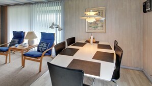 Un comedor con una mesa, sillas y una lámpara.