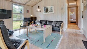 Ein geräumiges Wohnzimmer mit einer Couch, einem Couchtisch und einem Fernseher.