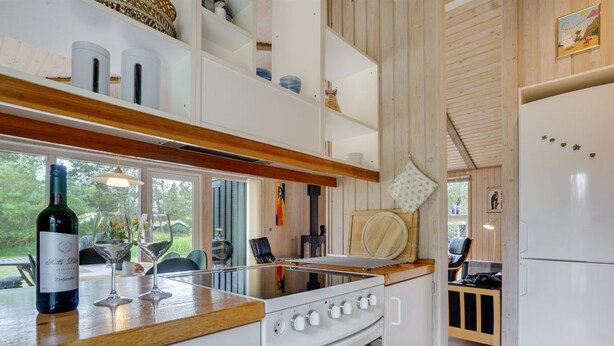 Eine moderne Küche mit weißen Schränken, einer Holz Arbeitsplatte und einem eingebauten Backofen.