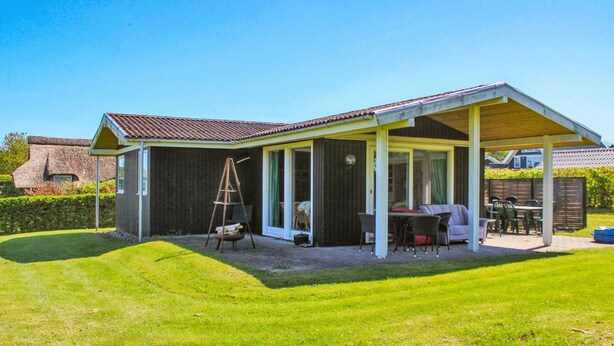A house with a covered patio, a swing set, and a lawn. - "Carita" - 500m from the sea by Interhome (Glesborg)