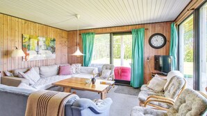 A cozy living room with a wooden ceiling, a sofa set, a coffee table, and a dining table. - "Carita" - 500m from the sea by Interhome (Glesborg)