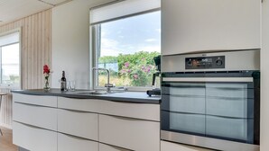 Una cocina moderna con horno empotrado y un amplio ventanal.