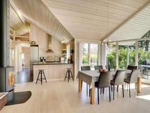 Eine moderne Küche mit Holzvertäfelung, einer Kochinsel und Barhocker.