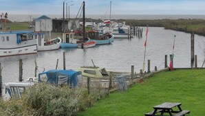 Een jachthaven met verschillende boten die aanmeren, een klein gebouw en een gazon met een picknicktafel.