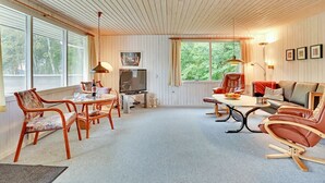 A cozy living room with a dining area, wooden ceiling, large windows, and a television. - "Leny" - 450m to the fjord by Interhome (Tarm)