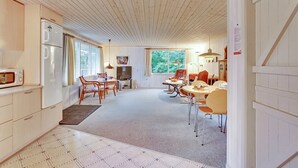A spacious kitchen with modern appliances, a dining area with a round table and chairs, and a cozy seating area with a sofa and armchairs. - "Leny" - 450m to the fjord by Interhome (Tarm)