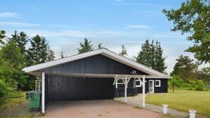 Un bâtiment noir avec un toit blanc et une zone abritée portant le numéro 17.