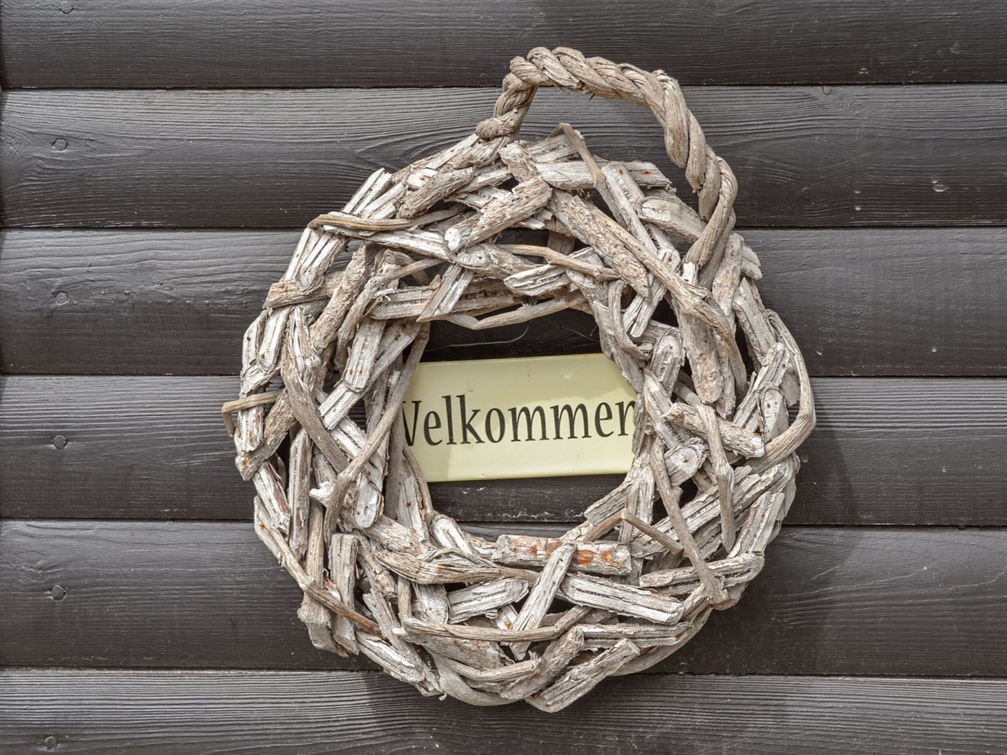 A rustic welcome wreath made of twigs and branches, with a label that reads "Welcome".