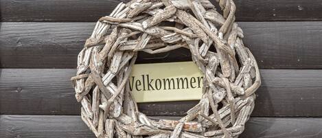 A rustic welcome wreath made of twigs and branches, with a label that reads "Welcome".