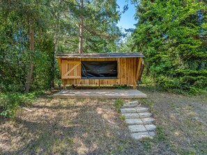 A wooden cabin with a large window, surrounded by trees. - "Pauna" - 50m from the sea by Interhome (Væggerløse)