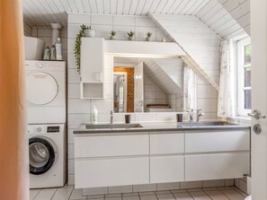 Una cucina moderna con lavatrice integrata, un ampio specchio e una finestra con vista esterna.
