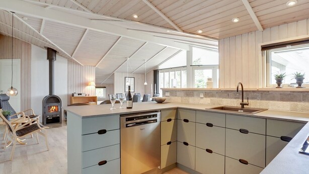 A modern kitchen with a built-in stove, a dishwasher, and a large island with a sink. - "Justiina" - 800m from the sea by Interhome (Væggerløse)