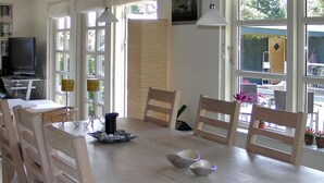 A dining area with a wooden table, chairs, and a television on a stand. - "Nitis" - 200m from the sea by Interhome (Væggerløse)