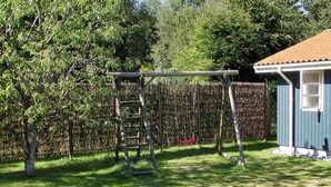 A backyard with a wooden swing set, a ladder, and a small shed. - "Nitis" - 200m from the sea by Interhome (Væggerløse)