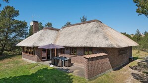 A thatched-roof cottage with a patio, brick walls, and a satellite dish. - "Satzur" - 800m from the sea by Interhome (Blåvand)