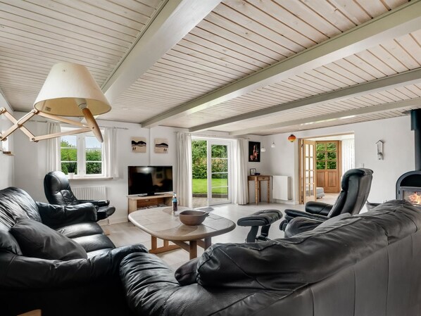 A spacious living room with a large leather sofa, a television, and a fireplace. - "Aliza" - 300m to the fjord by Interhome (Roslev)