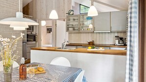 A modern kitchen with wooden cabinets, a central island, and pendant lighting. - "Wilgrib" - 400m from the sea by Interhome (Højby)