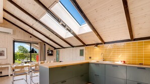 Una cocina moderna con una isla grande, tragaluces y vistas al exterior.