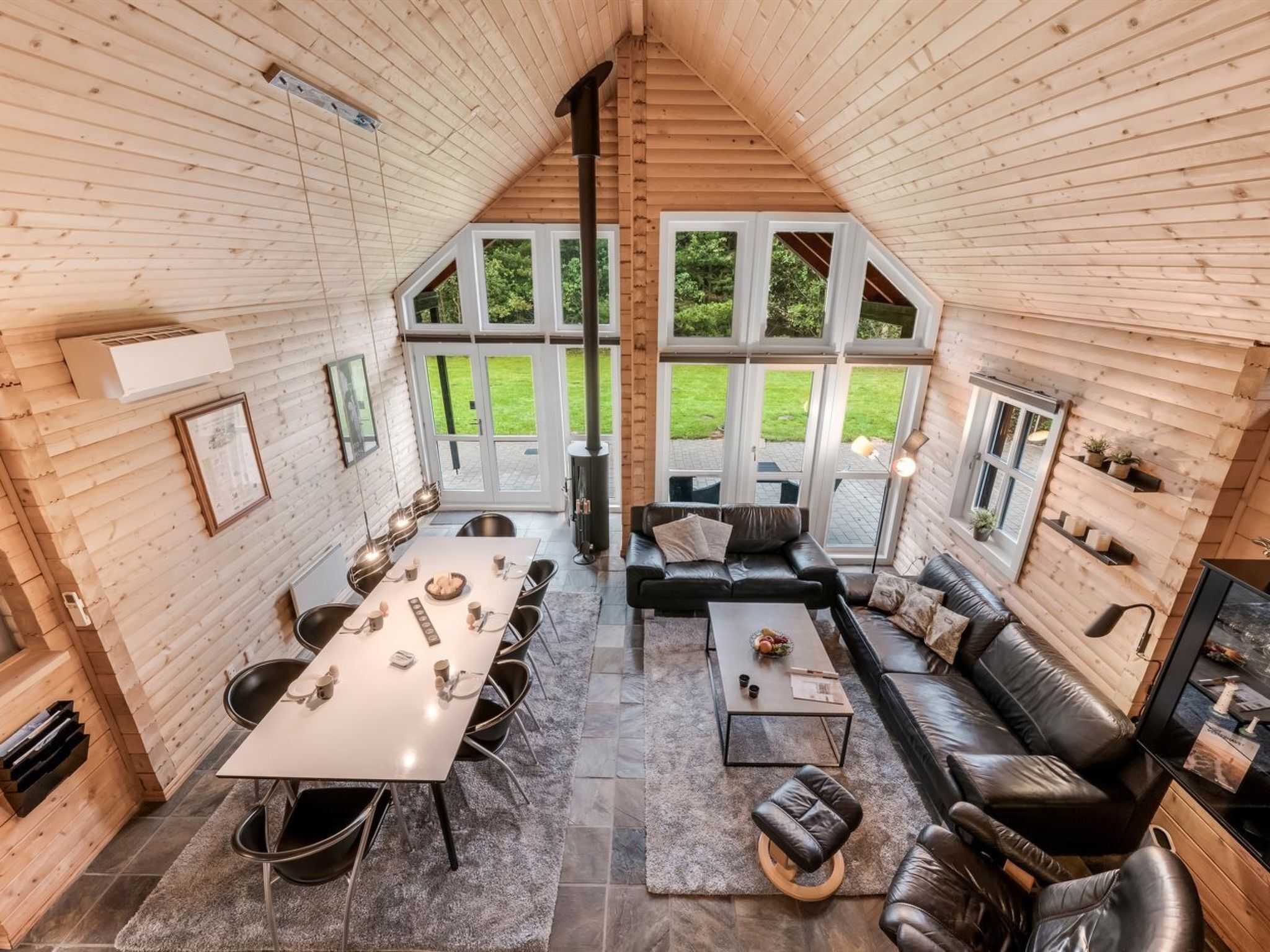 Un intérieur chaleureux avec un coin repas, un canapé et une cheminée.