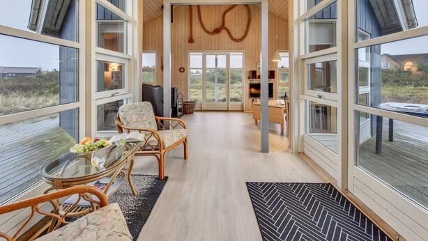 Un intérieur spacieux avec de grandes fenêtres, un espace central ouvert et un coin repas.