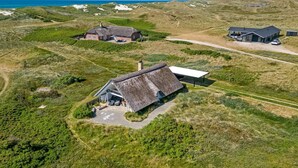 A thatched-roof house with a garden, a modern building, and a dune landscape. - "Klimentina" - 150m from the sea by Interhome (Ringkøbing)