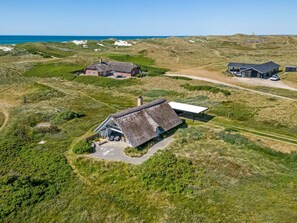 A thatched-roof house with a garden, a modern building, and a dune landscape. - "Klimentina" - 150m from the sea by Interhome (Ringkøbing)