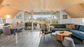 A spacious loft with a high ceiling, a dining area, a sofa, and a view of the outdoors. - "Klimentina" - 150m from the sea by Interhome (Ringkøbing)