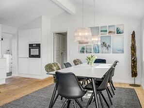 A modern dining area with a white table, black chairs, and a black and white rug. - "Wiebke" - 200m from the sea by Interhome (Blokhus)