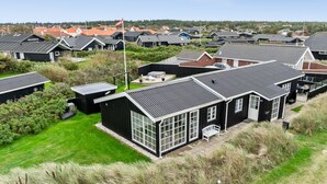 A residential area with multiple houses, each featuring a distinct architectural style with dark roofs and white trim. - "Wiebke" - 200m from the sea by Interhome (Blokhus)