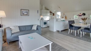 A modern, open-plan living space with a grey sofa, a white coffee table, and a dining area with a round table and chairs. - "Lilja" - 1.5km from the sea by Interhome (Fanø)