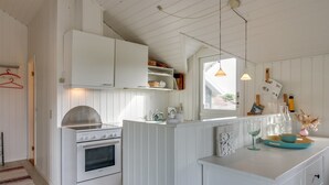 A kitchen with white cabinetry, a stove, and a countertop with a sink. - "Lilja" - 1.5km from the sea by Interhome (Fanø)