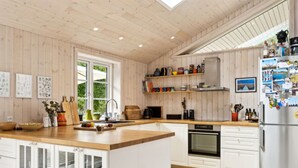 Una cocina moderna con armarios de madera, una isla central y un horno empotrado.