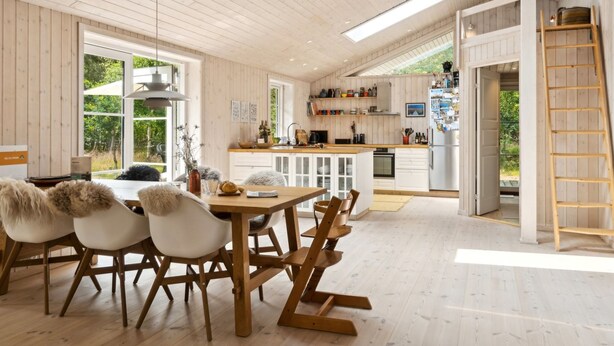 Una cocina amplia con armarios de madera, una isla central y vistas al exterior.