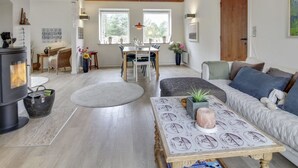 Un salón espacioso con chimenea, una mesa de comedor y un sofá.