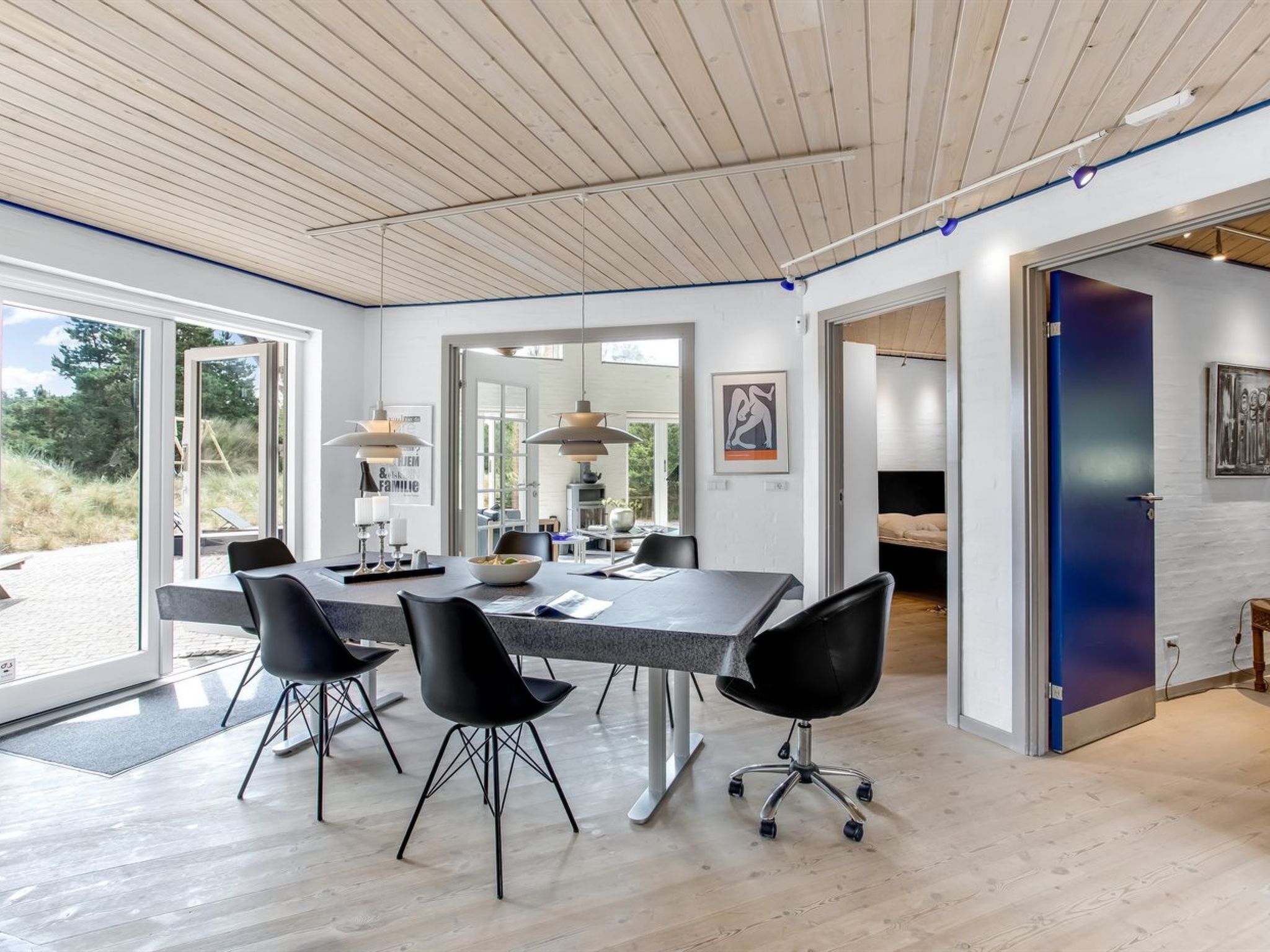 Ein modernes Interieur mit Essbereich, offener Raumgestaltung und großen Fenstern.