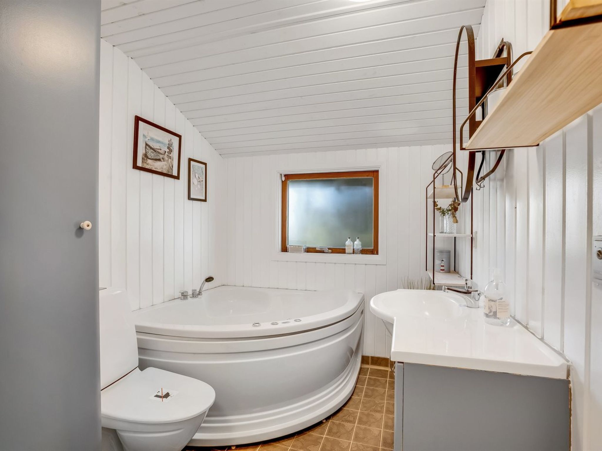 A bathroom with a large bathtub, a toilet, and a sink.