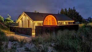 A house with a prominent arched entrance and a sloped roof, surrounded by natural landscape. - "Teoline" - 500m to the fjord by Interhome (Hvide Sande)