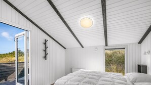 A bedroom with a large bed, a ceiling light, and a door leading to an outdoor area. - "Teoline" - 500m to the fjord by Interhome (Hvide Sande)