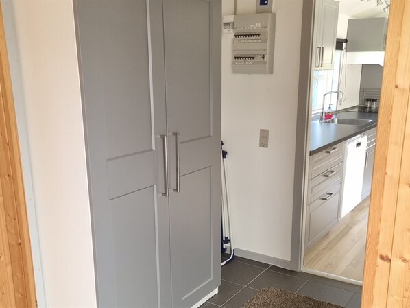 A kitchen with grey cabinets, a white countertop, and a built-in electrical panel.