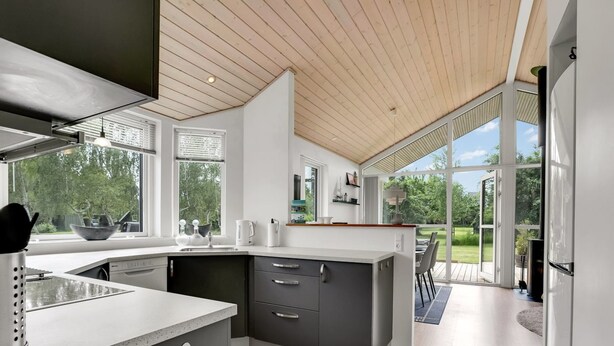 Una cocina moderna con una isla grande, electrodomésticos integrados y vistas al exterior.